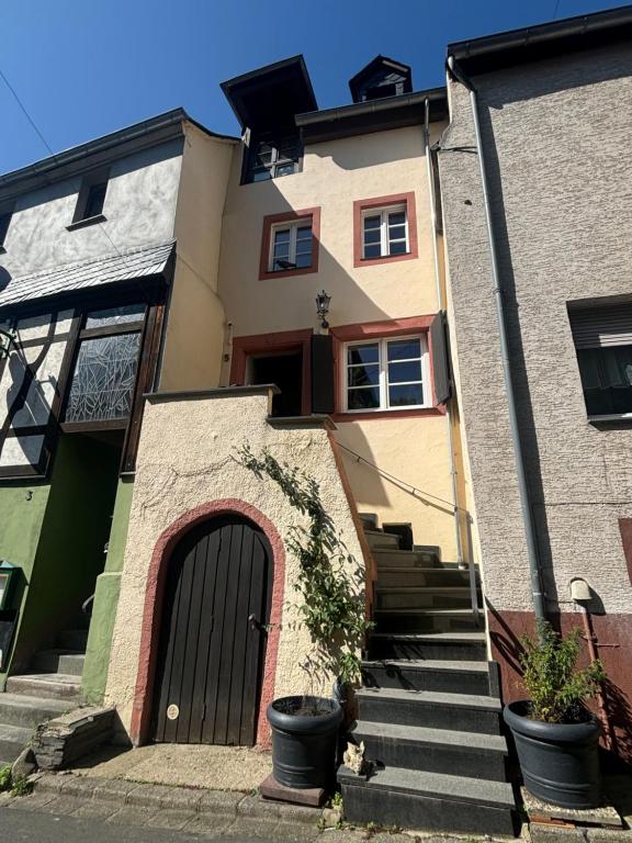 a house with a black door and stairs at Fuchsbau in Lieser