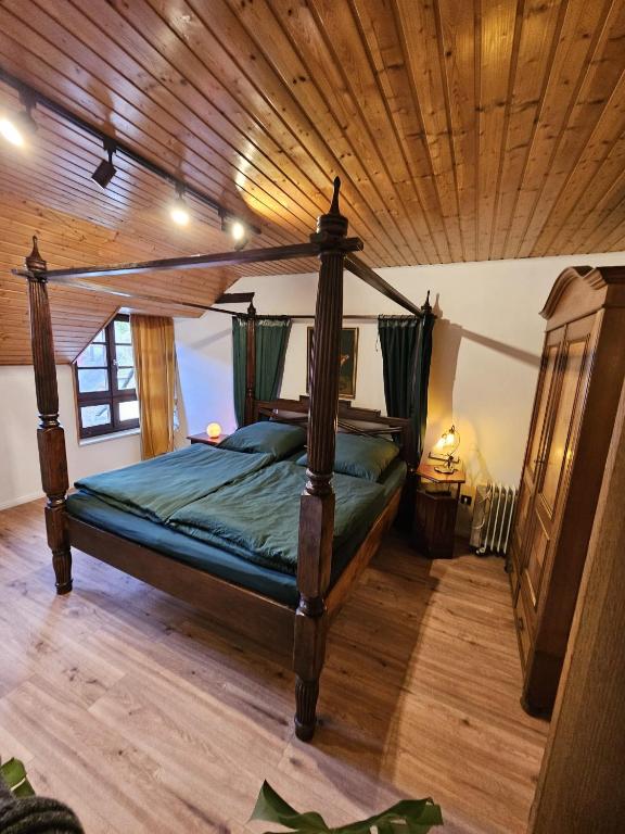 a bedroom with a canopy bed and a wooden ceiling at Fuchsbau in Lieser