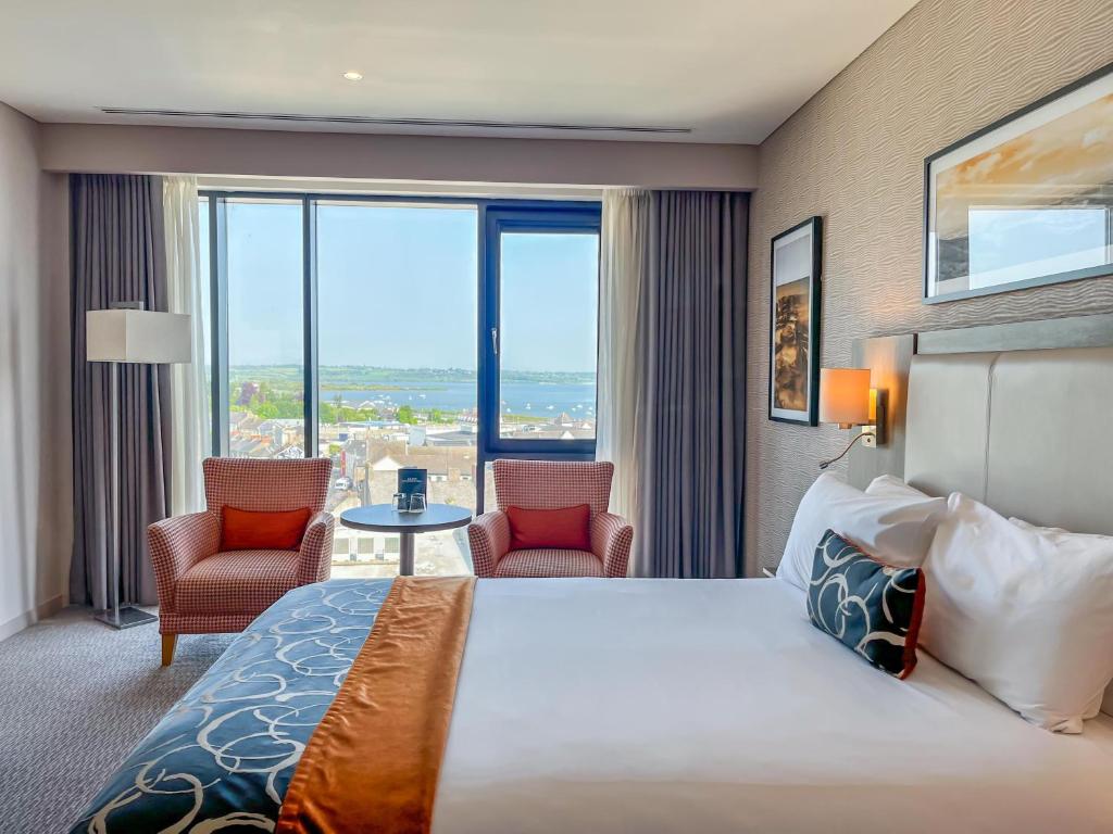 a hotel room with a large bed and two chairs at Whites of Wexford in Wexford