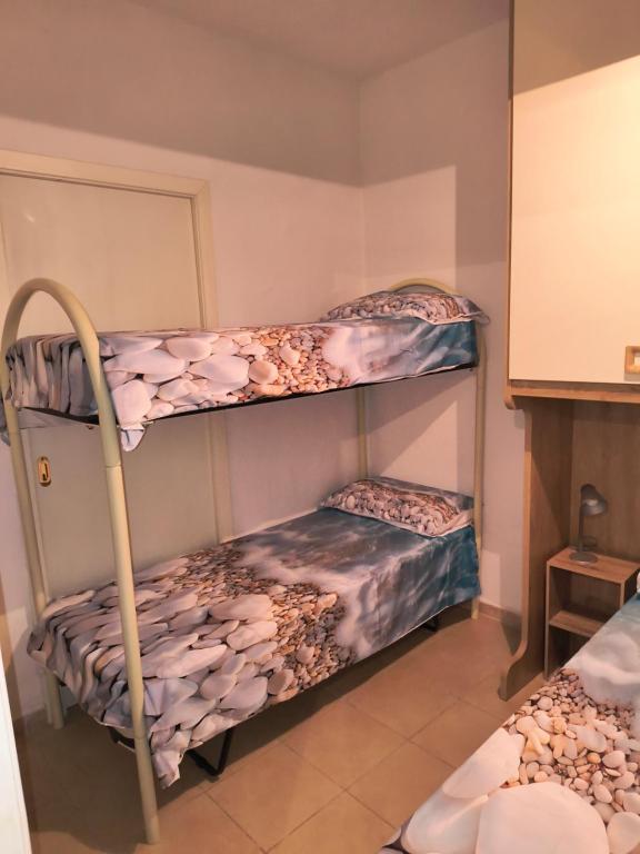 2 literas en una habitación con otra cama en casa vacanze baia safò, en Briatico