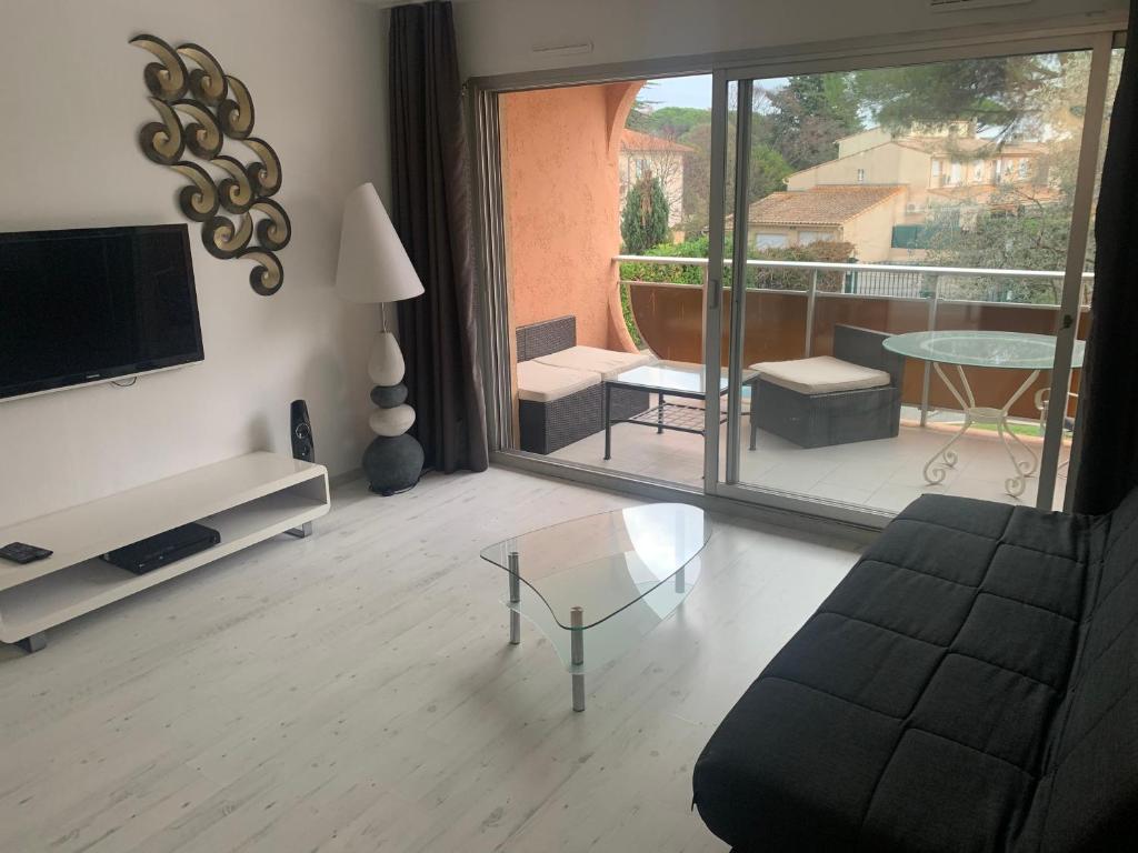 un salon avec un canapé et une table en verre dans l'établissement Studio au calme, à Vallauris