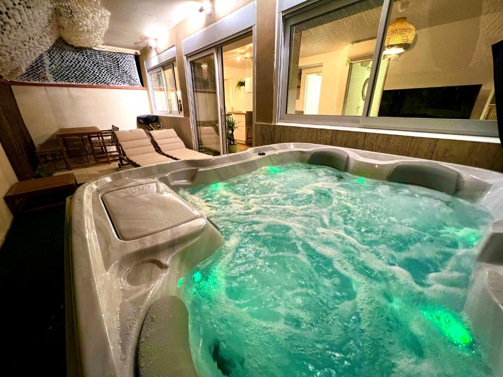 - une baignoire jacuzzi avec eau bleue dans la chambre dans l'établissement Luxueux appartement à 50m du front de mer, à Canet