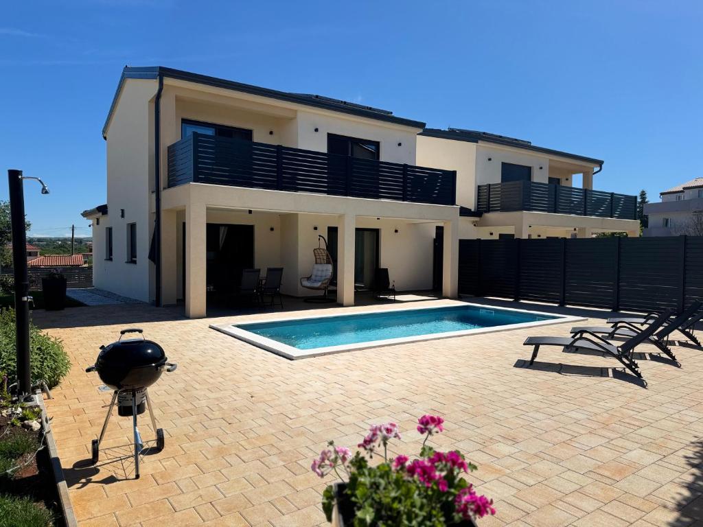 a house with a swimming pool in front of it at Villa Mario in Poreč