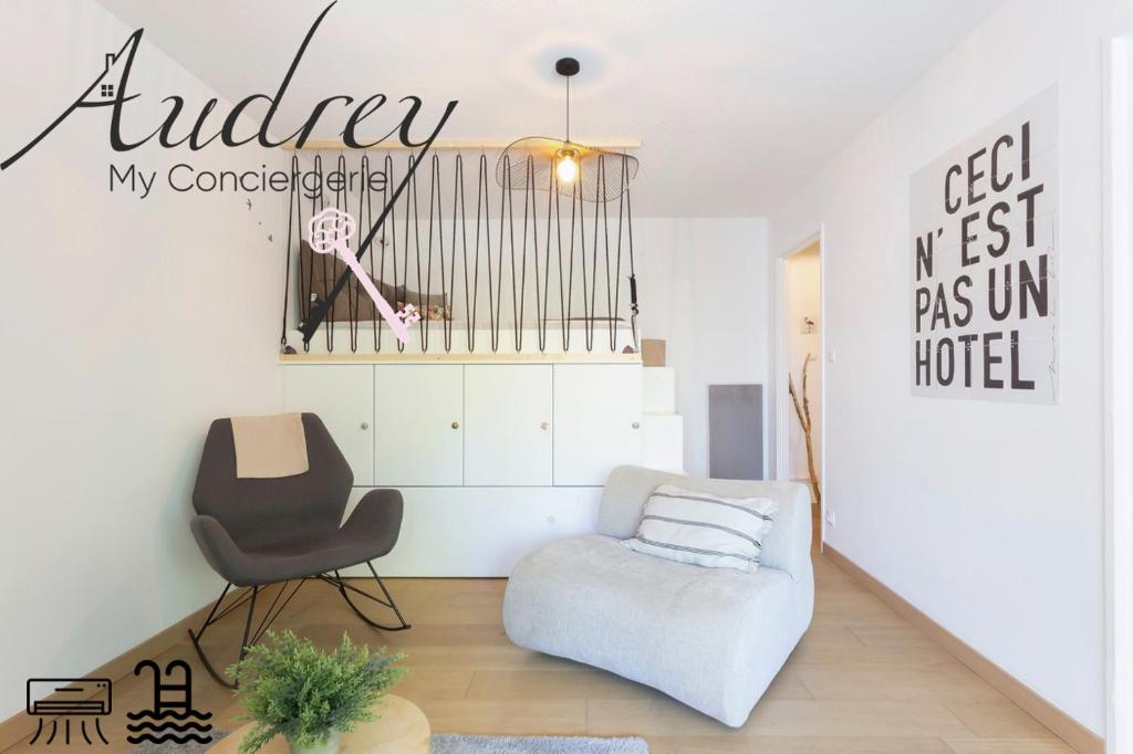 ein Wohnzimmer mit einer Couch und einem Sessel in der Unterkunft Chez Stéphanie De - Superbe studio design en centre ville avec piscine in La Grande-Motte