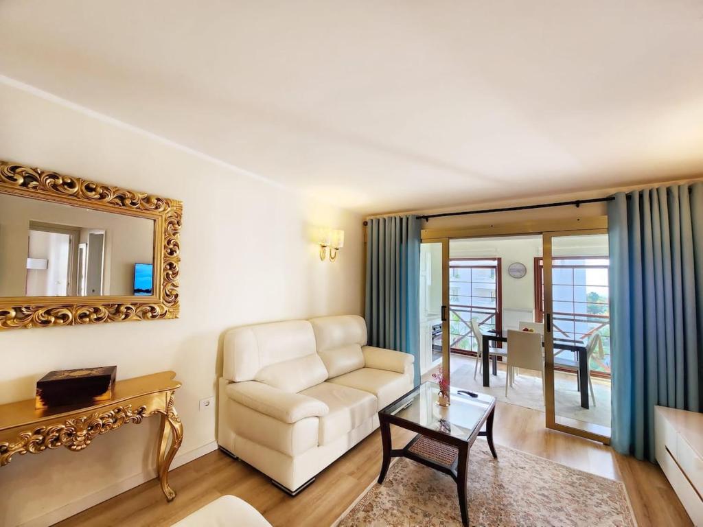 a living room with a white couch and a mirror at Luxury unique central flat with 2 swimming pools in Playa de las Americas
