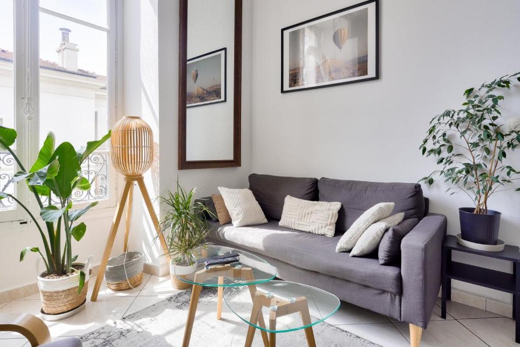 - un salon avec un canapé gris et des plantes dans l'établissement Stunning 2BR Flat in the heart of Nice, à Nice