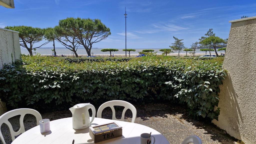 a table and chairs with a view of the beach at Saint Georges de Didonne - VUE MER pour ce STUDIO COSY en rez-de-chaussée in Saint-Georges-de-Didonne