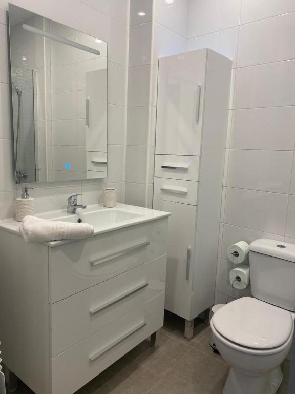 a white bathroom with a toilet and a sink at Casa esperanza in Soria