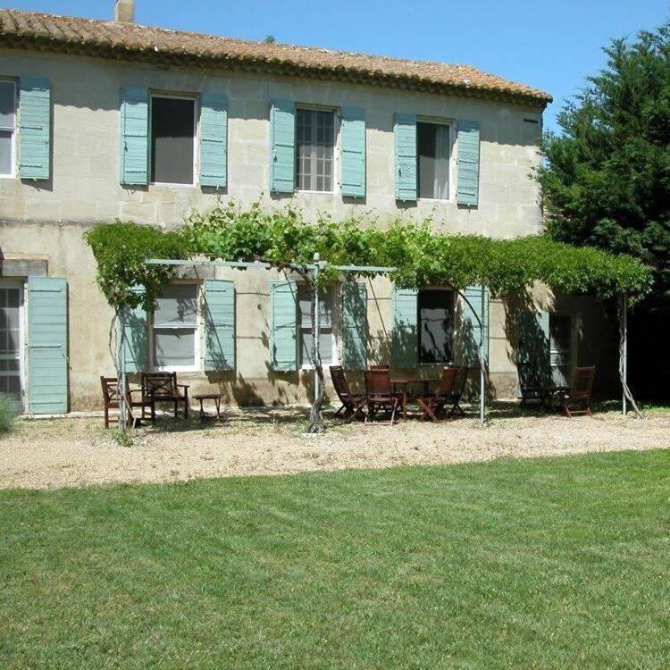 une maison avec des volets bleus et des chaises devant elle dans l'établissement MAS for Camargue lovers, à Arles