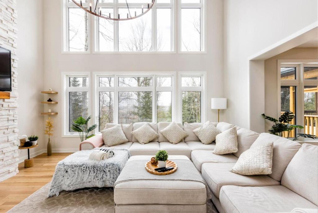 Lake of BaysShooting Star Lodge BBQ Firepit SPA Relax的白色的客厅设有白色的沙发和窗户。