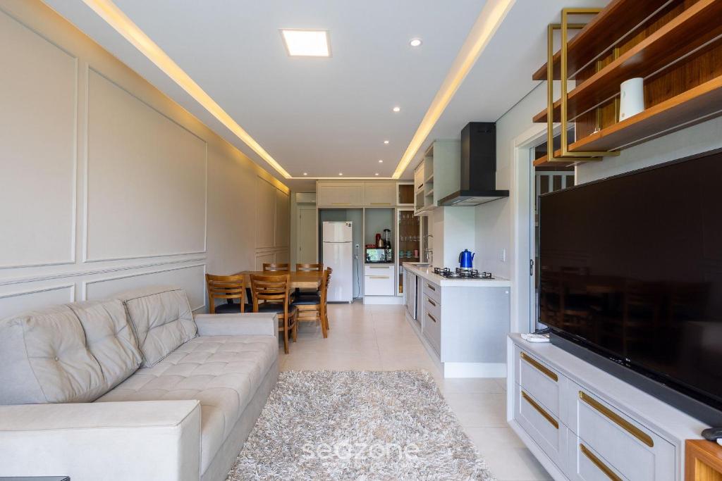 a living room with a couch and a kitchen at Apto 2Q c/ churrasq. prox da praia - BC - STL401 in Balneário Camboriú