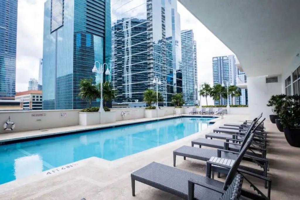 a pool with chairs and a view of the city at Exclusive 2BR APT Brickell Free Parking in Miami