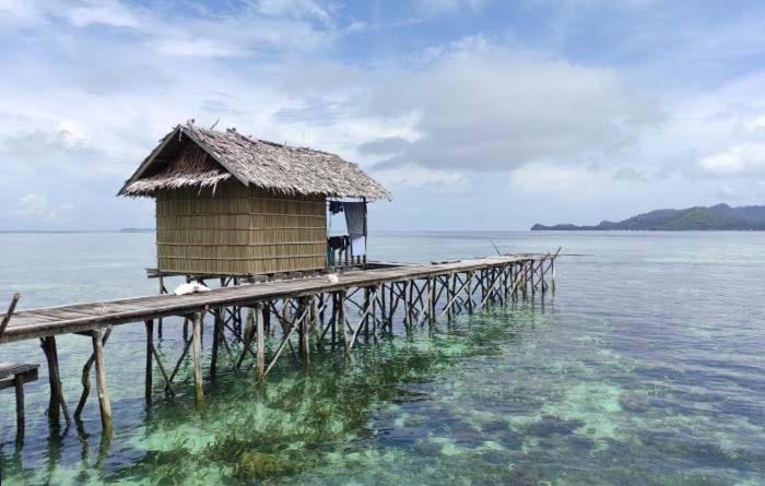 a small hut on a pier in the water at Homestay Yenbeyar Raja Ampat in Yariffi
