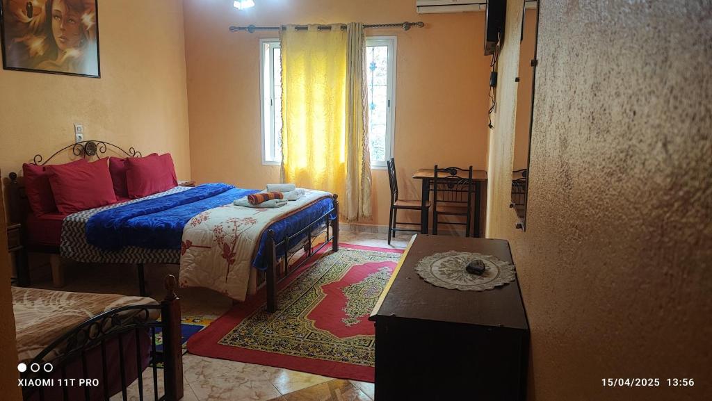 a small bedroom with two beds and a table at Maison Touria in Ouzoud