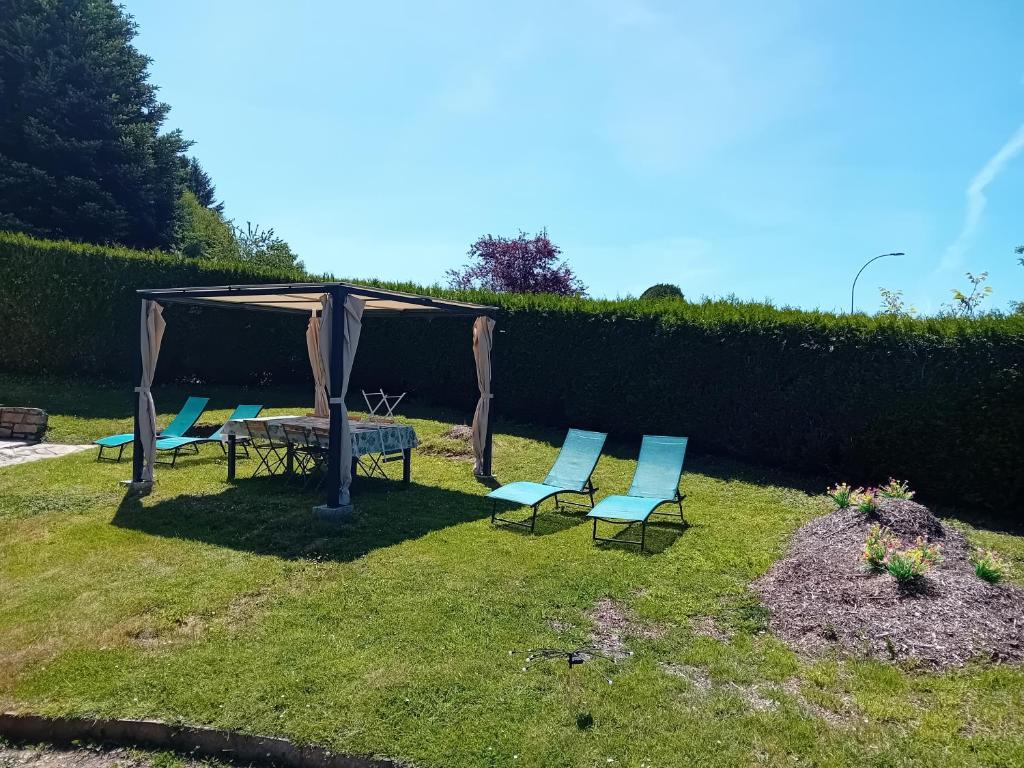 - un groupe de chaises et un kiosque dans la cour dans l'établissement Gîte Evasion Corrézienne, à Seilhac