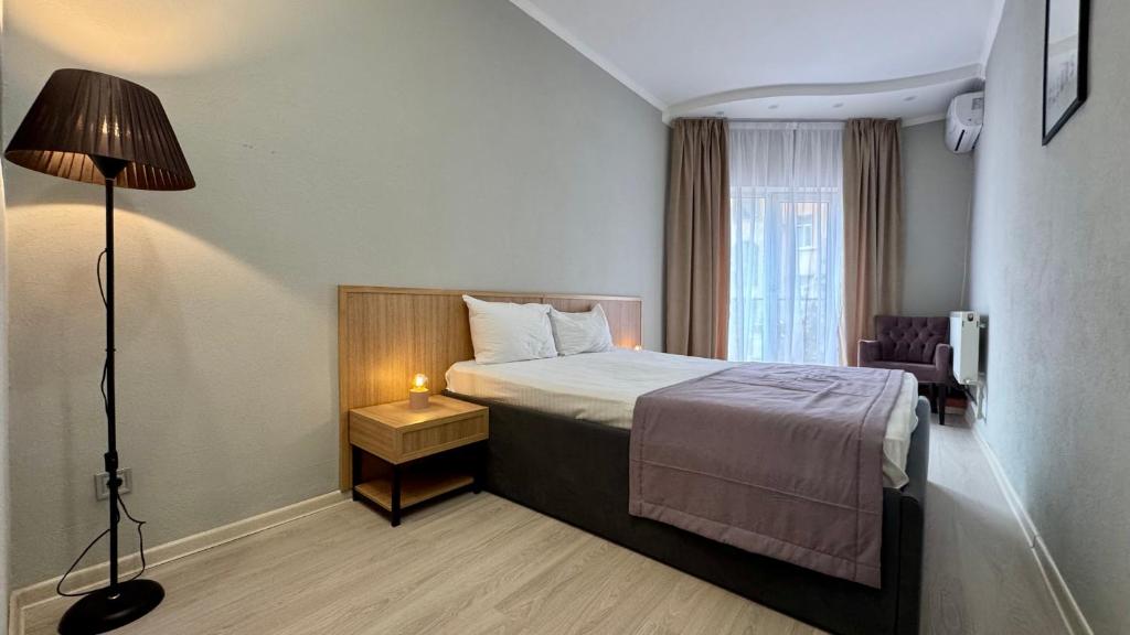 a hotel room with a bed and a lamp at Boomerang Apartments in Odesa