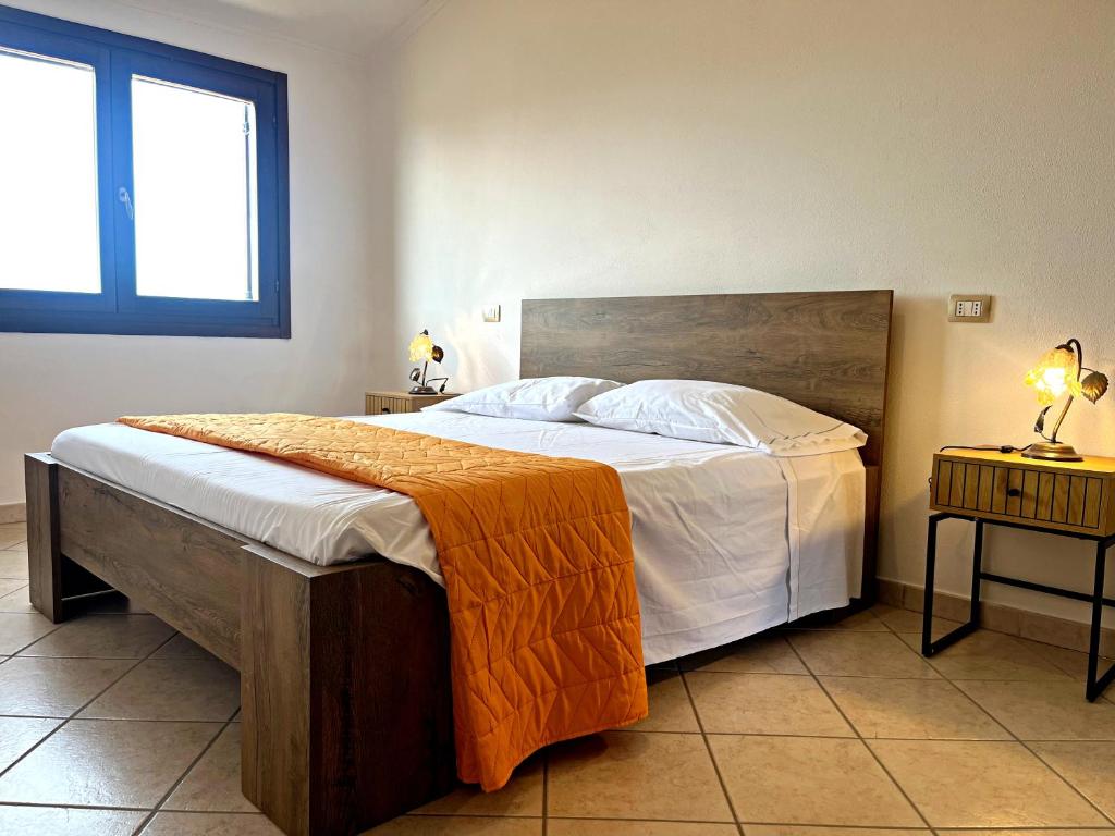 une chambre avec un grand lit et une fenêtre dans l'établissement La Casetta di Lally, à Cabras