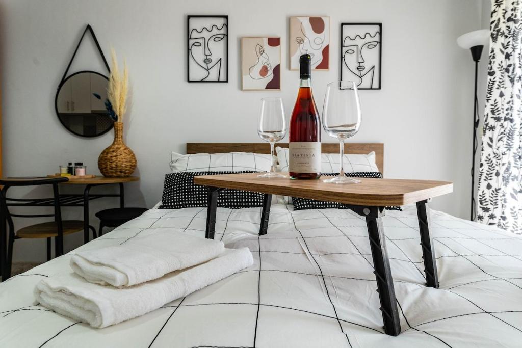 Una botella de vino y dos copas en una cama. en VPG Minimal Studios Traveller3, en Tesalónica