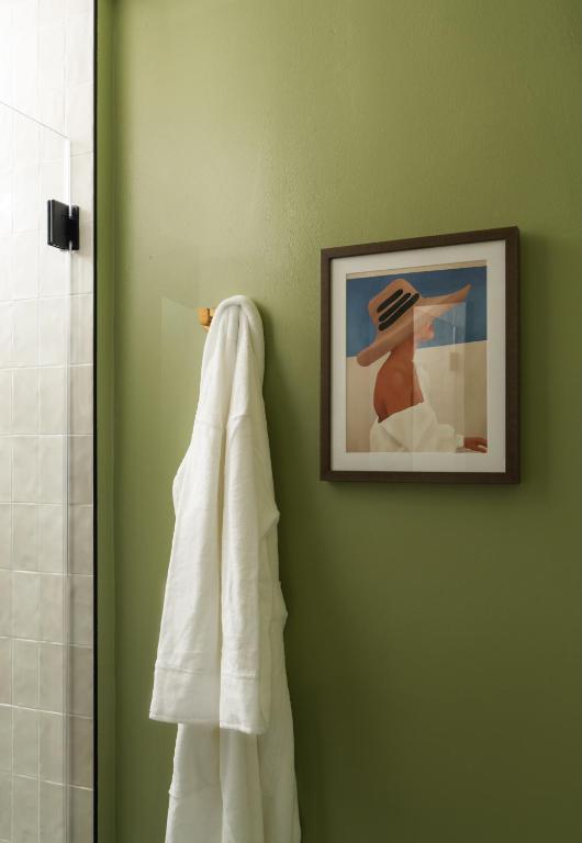 a bathroom with a towel hanging on a green wall at The Milo in Santa Barbara