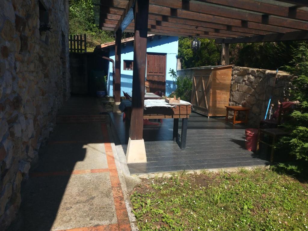 a patio with a table and a stone wall at Ribera del Sella III in Dego