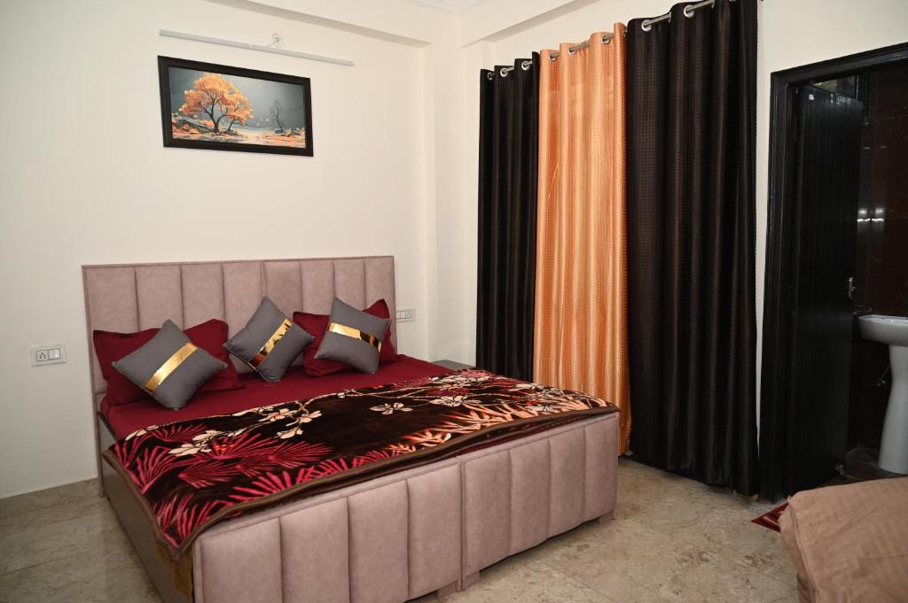 a bedroom with a large bed with red sheets and pillows at Castle INN Moutain Escape-3BHK Fully Loaded in Dehradun