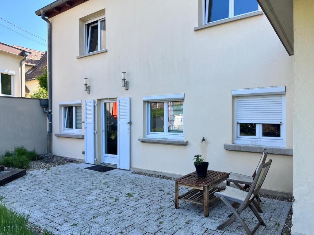 une chaise et une table devant une maison dans l'établissement Hébergement Ostwald, à Ostwald
