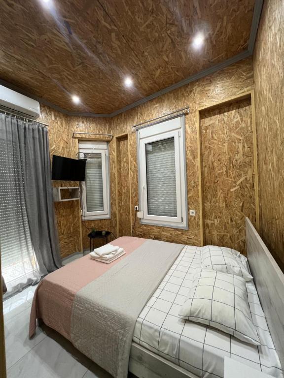 a bedroom with a bed and two windows at City Corner Stay in Kavala