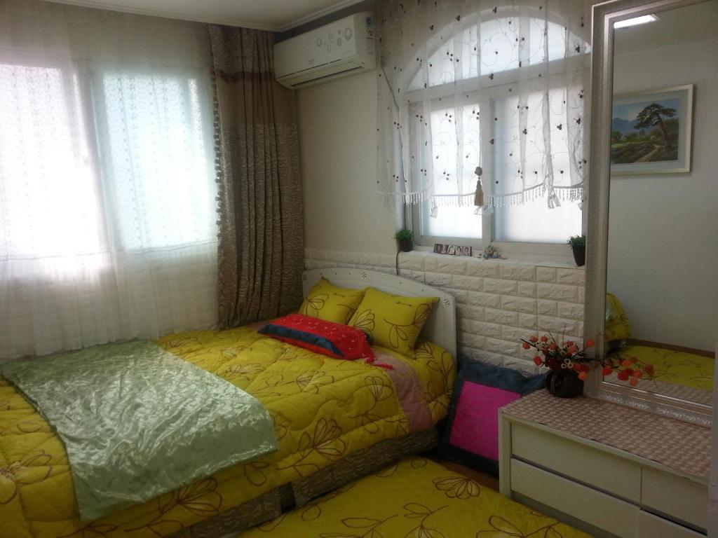 a small bedroom with a bed and a window at Homestay Eve in Seoul