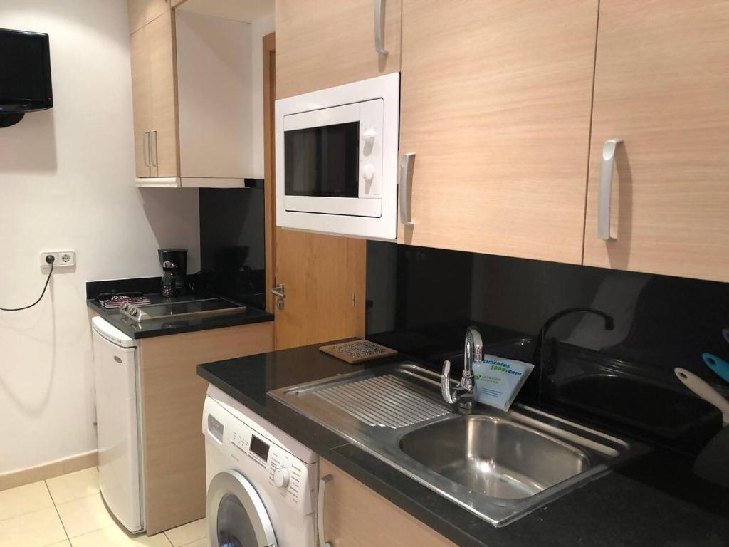 a small kitchen with a sink and a microwave at Sky 101 by Confortsky in Pas de la Casa