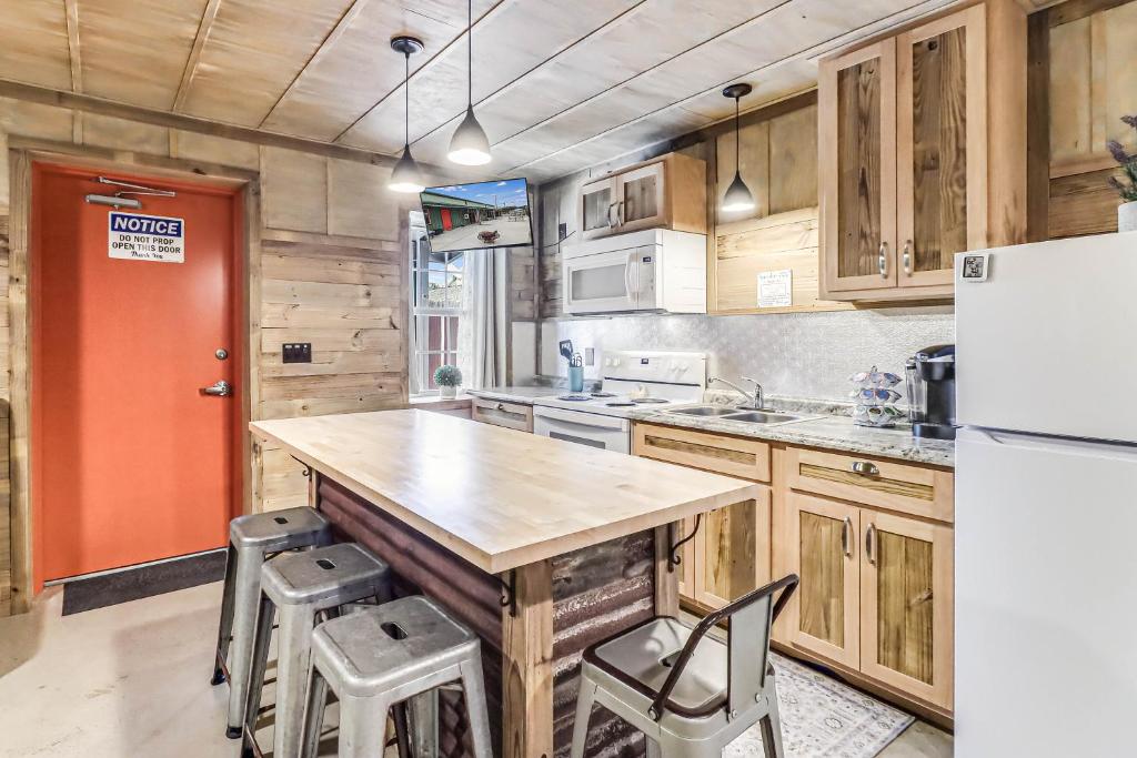 a kitchen with wooden cabinets and a large island with stools at Casas Coastal Experience Cabin C in Rockport