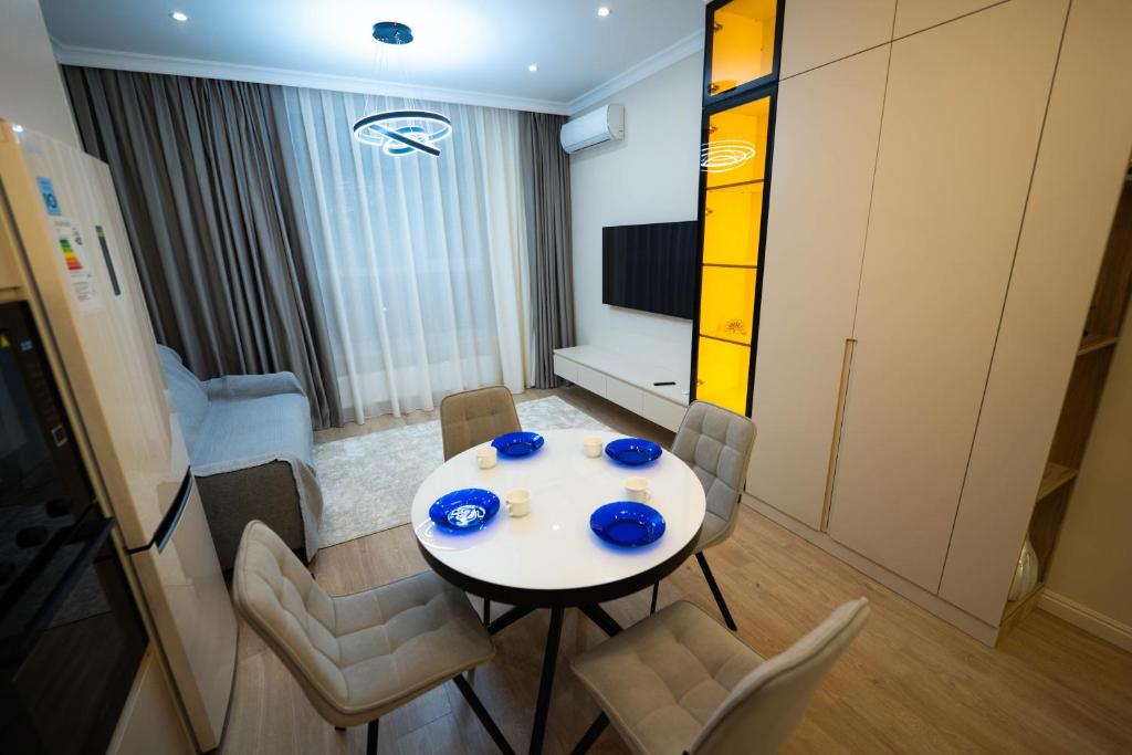 a room with a table and chairs and a television at ЖК Кристалл 160К7 15 этаж 846 in Almaty