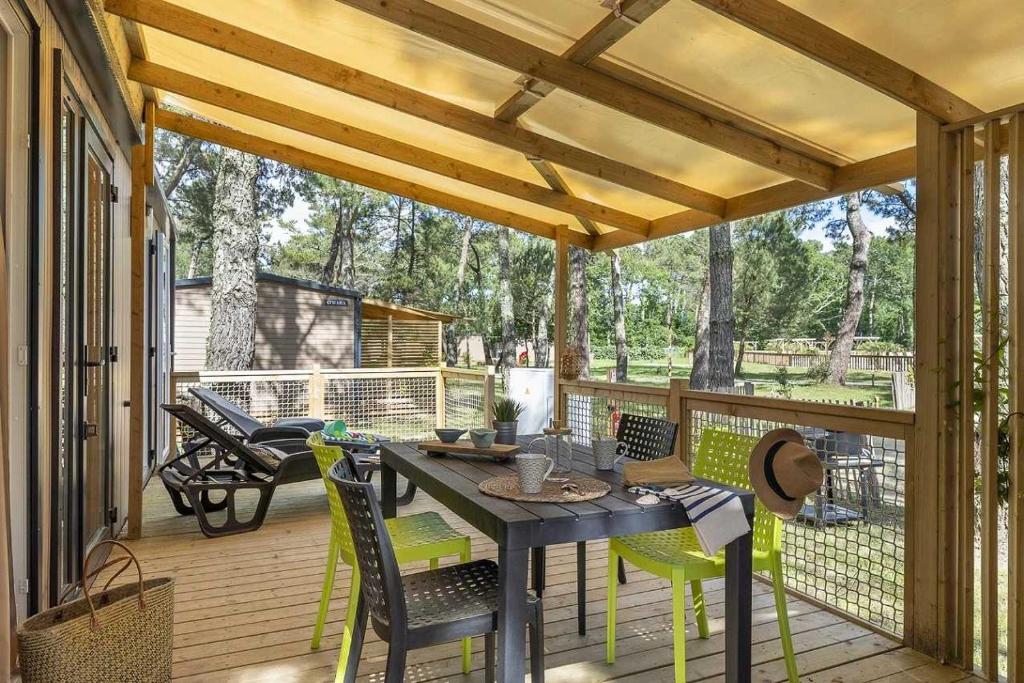 un patio avec une table et des chaises sur une terrasse dans l'établissement Camping 4 étoiles - Parc aquatique - ef0bbb, aux Mathes