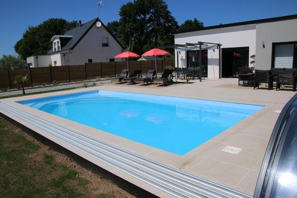una gran piscina azul junto a una casa en Superbe maison avec piscine privée, en Bénodet