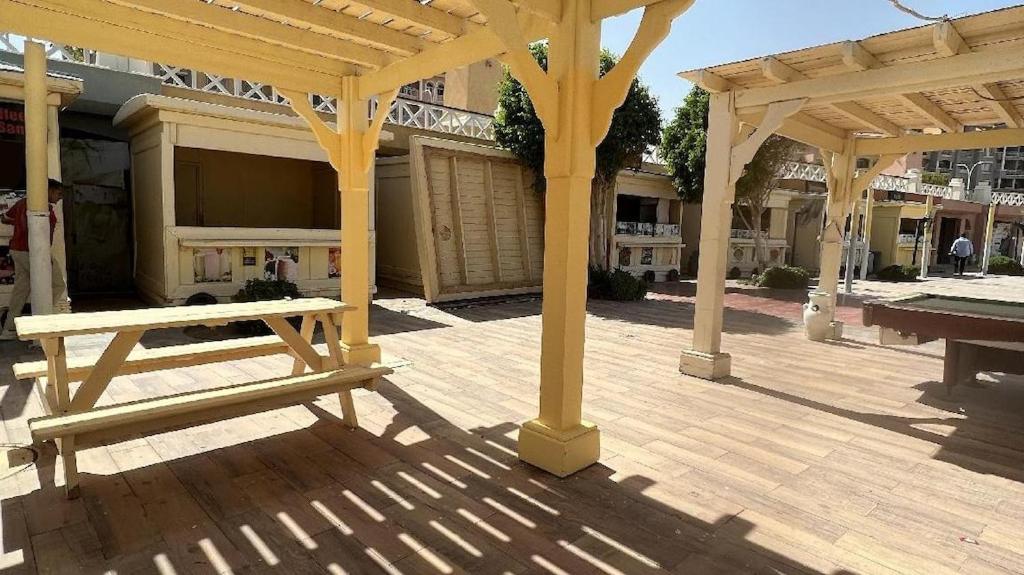 a wooden pergola with a bench in front of a building at ستوديو بورتو شرم الشيخ in Sharm El Sheikh