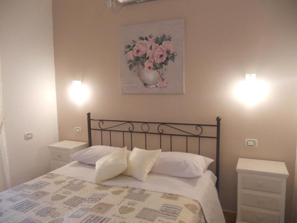 een slaapkamer met een bed met 2 nachtkastjes en 2 verlichting bij B&B Le Rose in Santa Maria di Castellabate