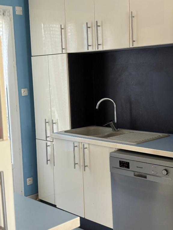 une cuisine avec des armoires blanches et un évier dans l'établissement Villa playa, à Valras-Plage