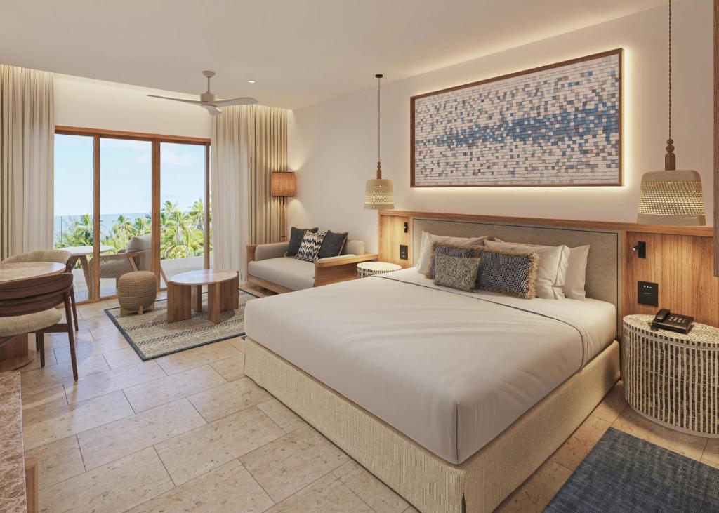 a bedroom with a large bed and a living room at Secrets Playa Mujeres Golf & Spa Resort - All Inclusive Adults Only in Cancún