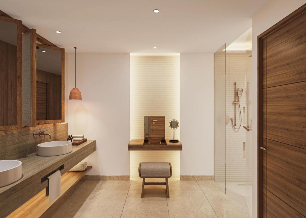 a bathroom with a sink and a chair in it at Secrets Playa Mujeres Golf & Spa Resort - All Inclusive Adults Only in Cancún