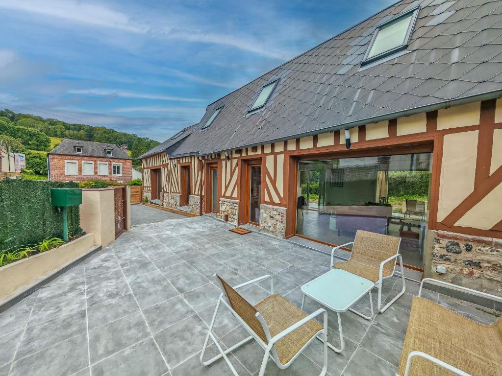 d'une terrasse avec des chaises et une table. dans l'établissement Belle Maison Honfleuraise 10-14 pers piscine, à Fatouville-Grestain