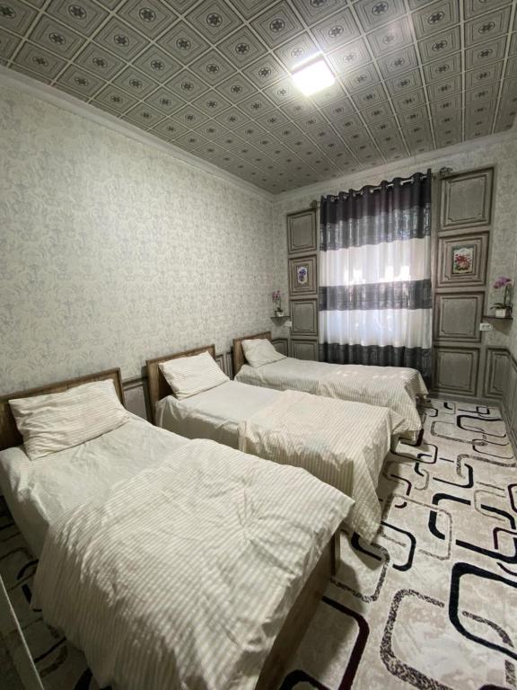 a room with three beds and a coffered ceiling at Family hostel Toshkent in Toshkent-Passajir Bekati