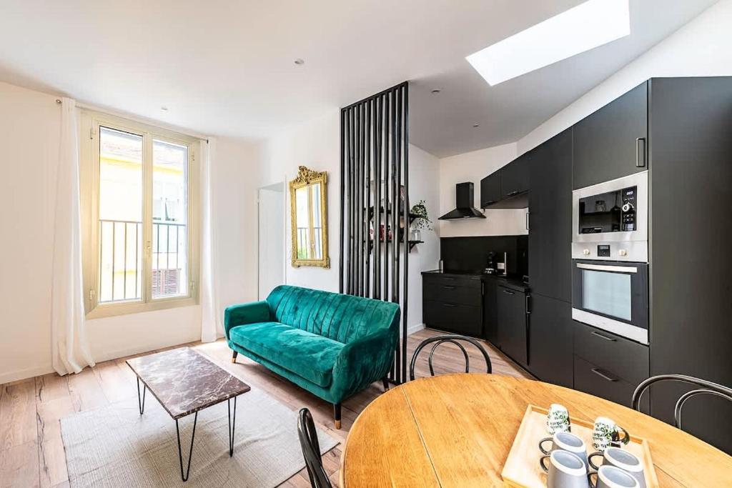 un salon avec un canapé vert et une table dans l'établissement LX151 Calme confort & style en coeur de ville, à Menton