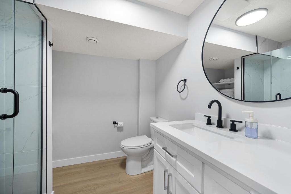 a bathroom with a toilet and a mirror at Flora's House in Calgary