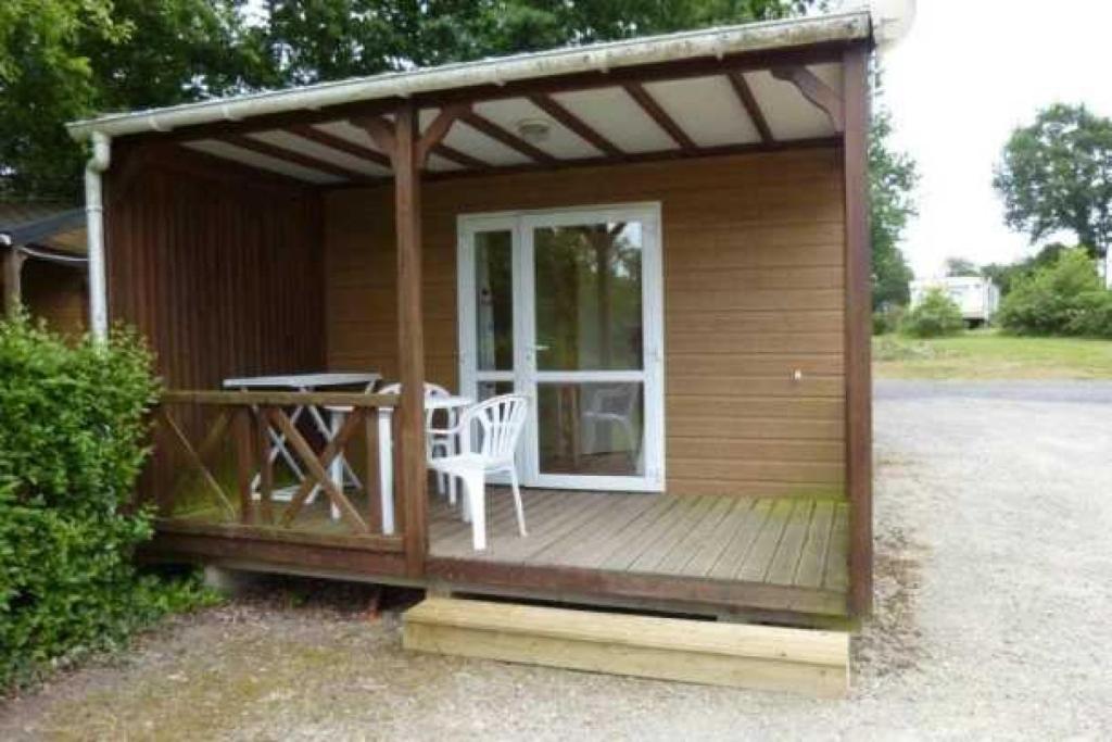 une petite cabine avec une table et des chaises sur une terrasse dans l'établissement Camping 3 étoiles - ccaa0ib, à Sainte-Reine-de-Bretagne