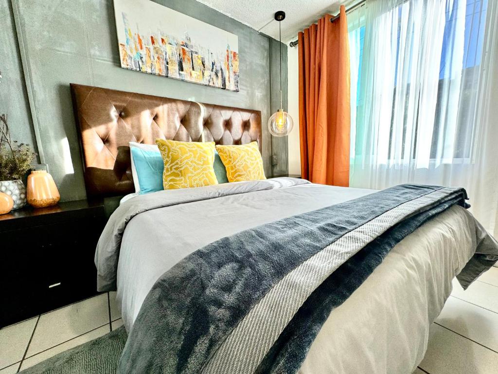 ein Schlafzimmer mit einem großen Bett mit bunten Kissen in der Unterkunft Casa YON pet friendly, Netflix,free parking, factura, high speed wifi, Amazon Prime in Municipio Cuautitlán Izcalli