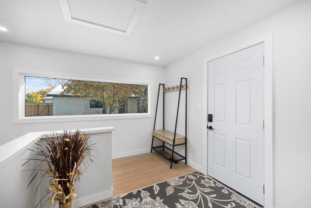a hallway with a white door and a window at Flora's House in Calgary