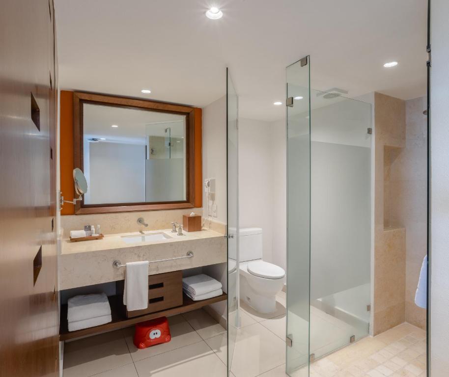 a bathroom with a shower and a sink and a toilet at Marival Emotions Resort & Suites Riviera Nayarit by Mercure in Nuevo Vallarta