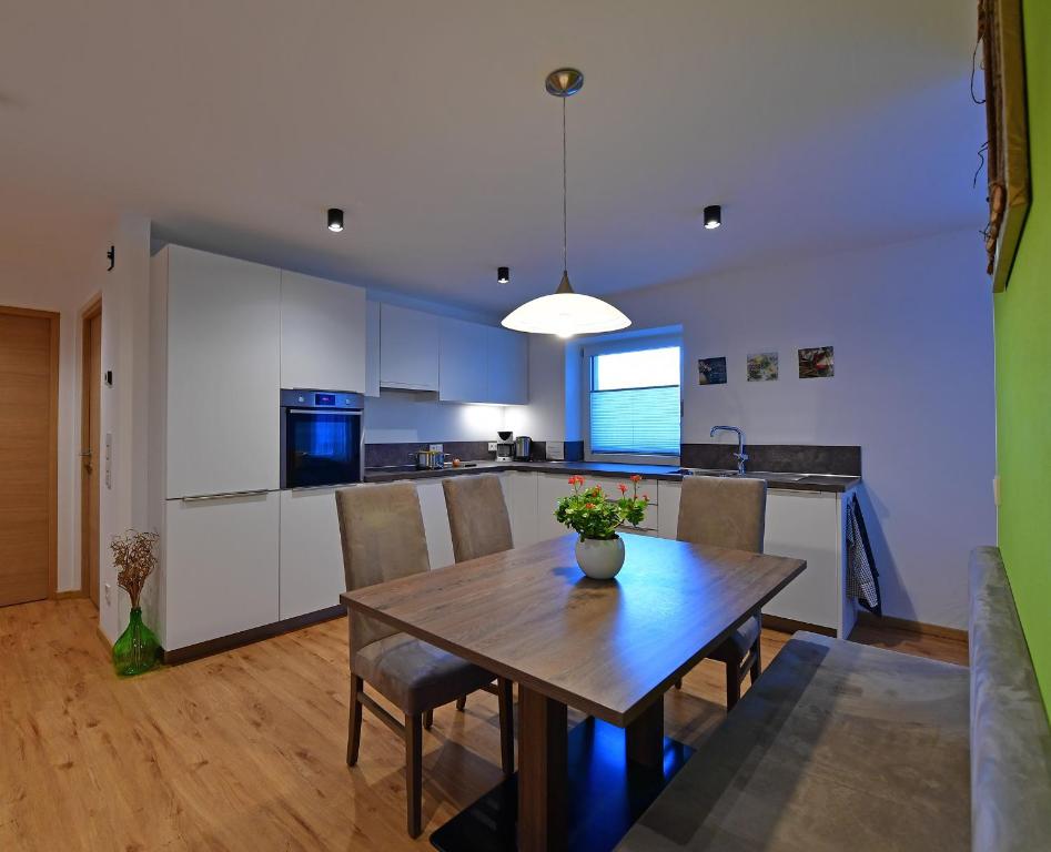 een keuken en eetkamer met een houten tafel bij Lärchenheim Appartment in Castelrotto