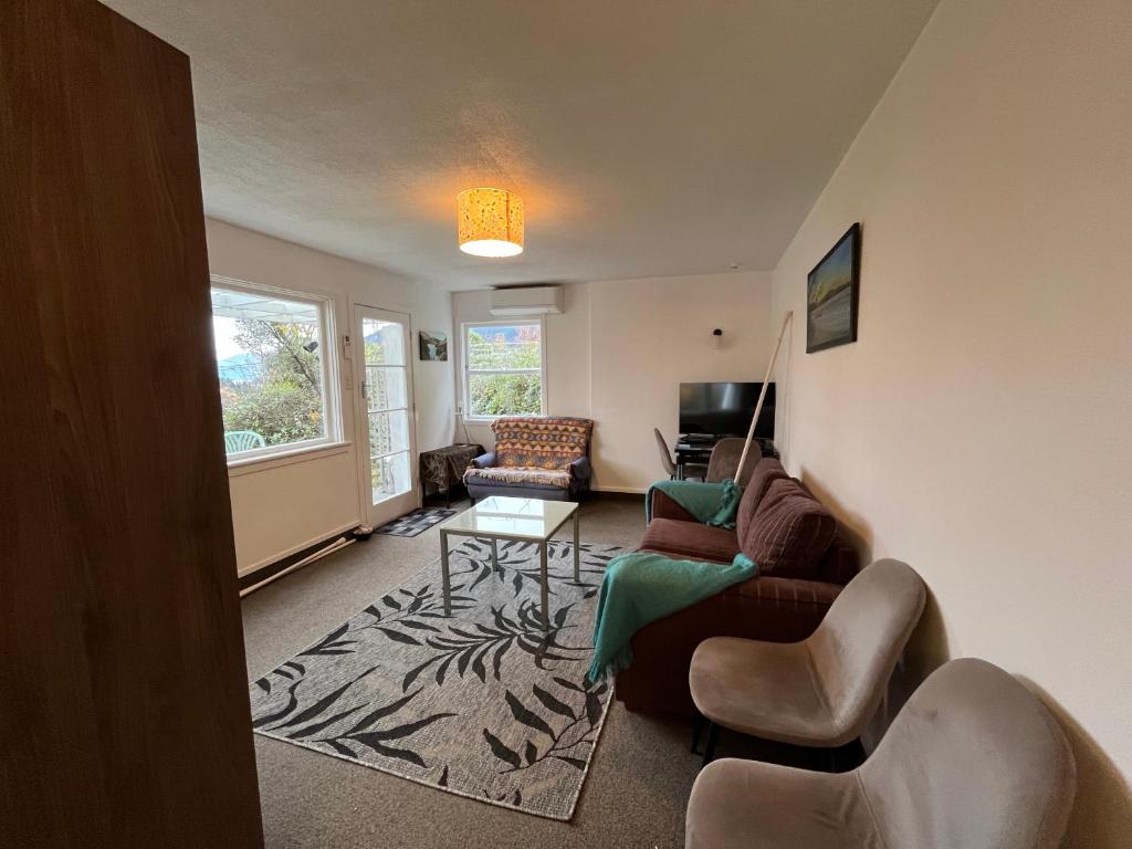 皇后镇Retro cosy unit with lake views and patio walk to town的带沙发和桌子的客厅