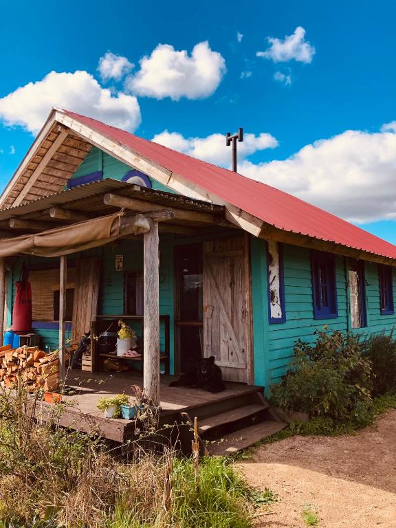 a small house with a red roof and a porch at Casa grande Los Manzanos in Aiguá