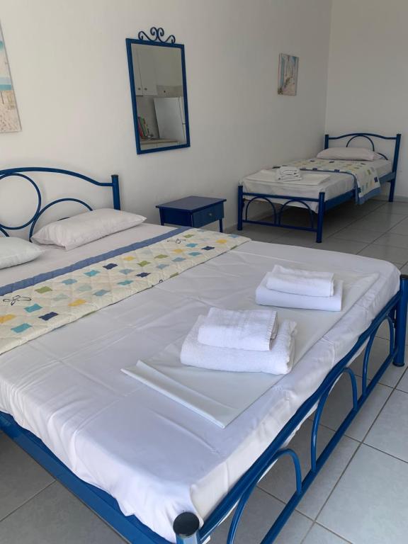 two beds in a room with towels on them at STUDIOs ARSINOI in Agia Paraskevi